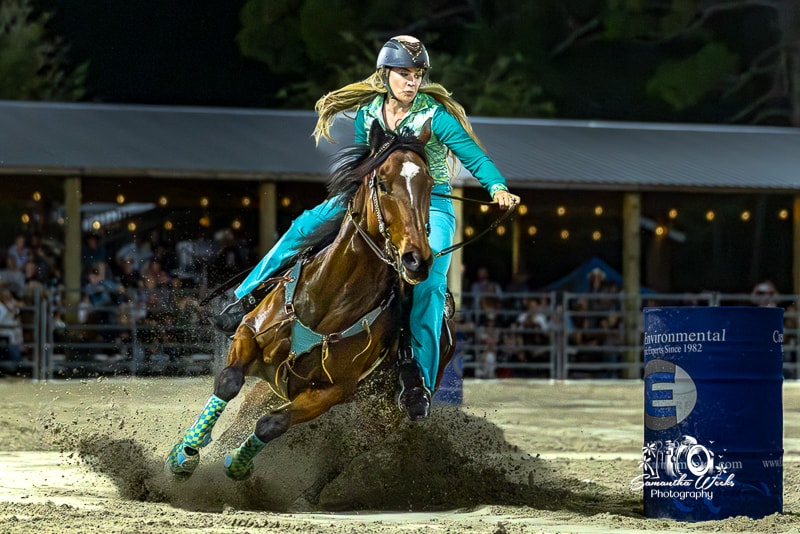 Barrel racer in pink shirt navigating tight turn