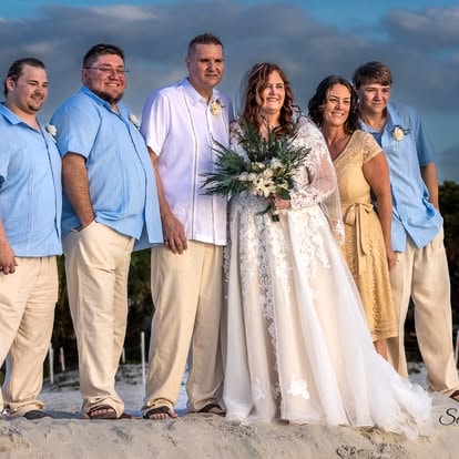 Wedding party group portrait on the beach at sunset