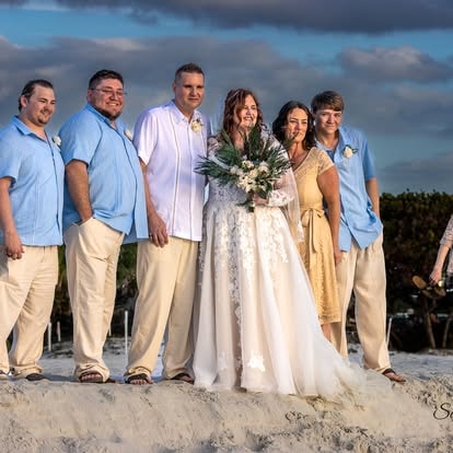 Wedding party laughing together on the beach