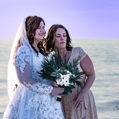 Two women at beach wedding ceremony