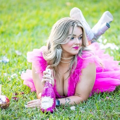 Woman in pink tutu lying on grass