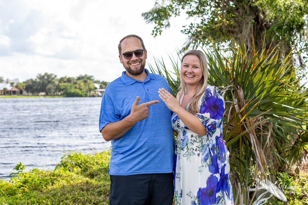 Couple posing by waterfront with tropical plants
