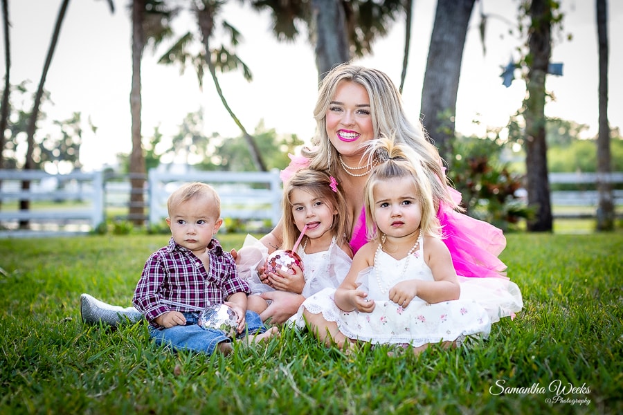 Woman with three young children on grass