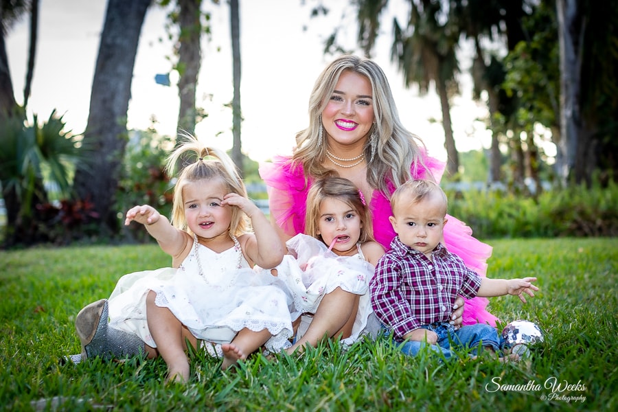 Woman with three young children on grass