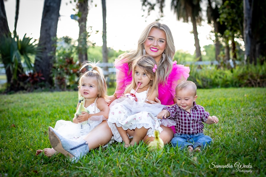 Woman with three young children on grass