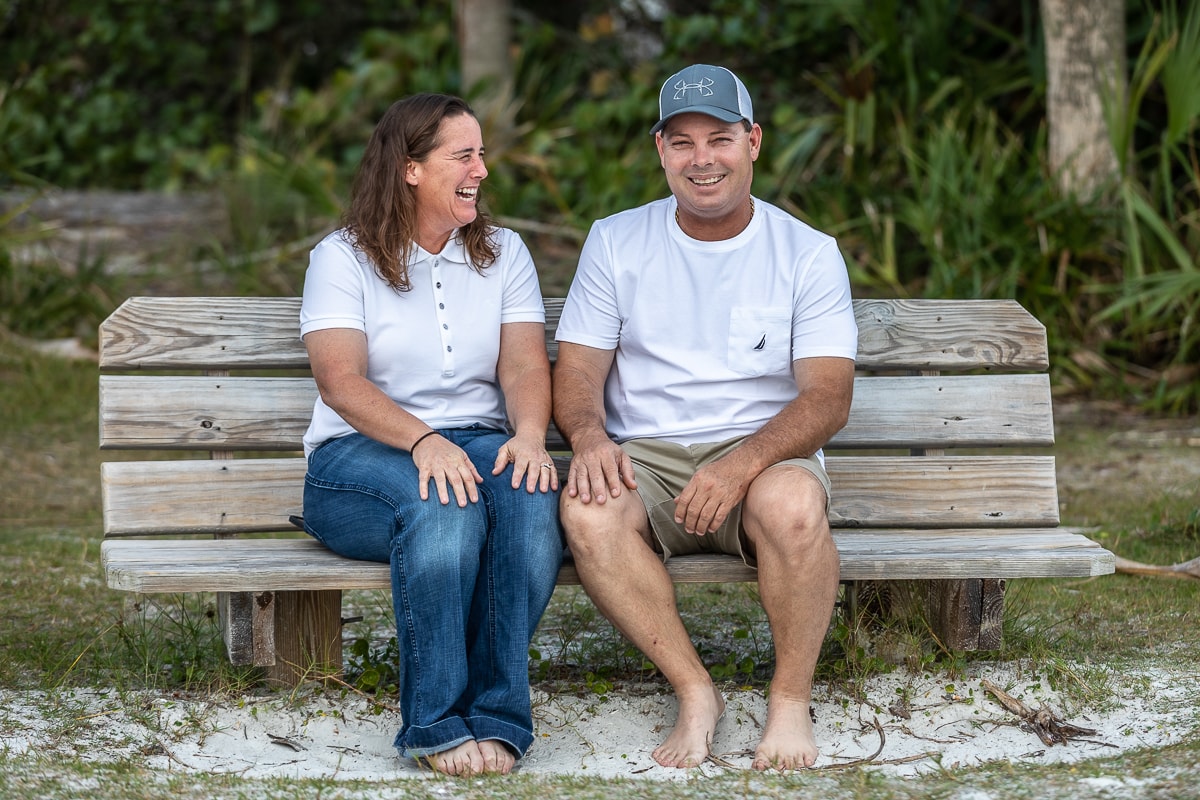 Couple laughing together on beach bench
