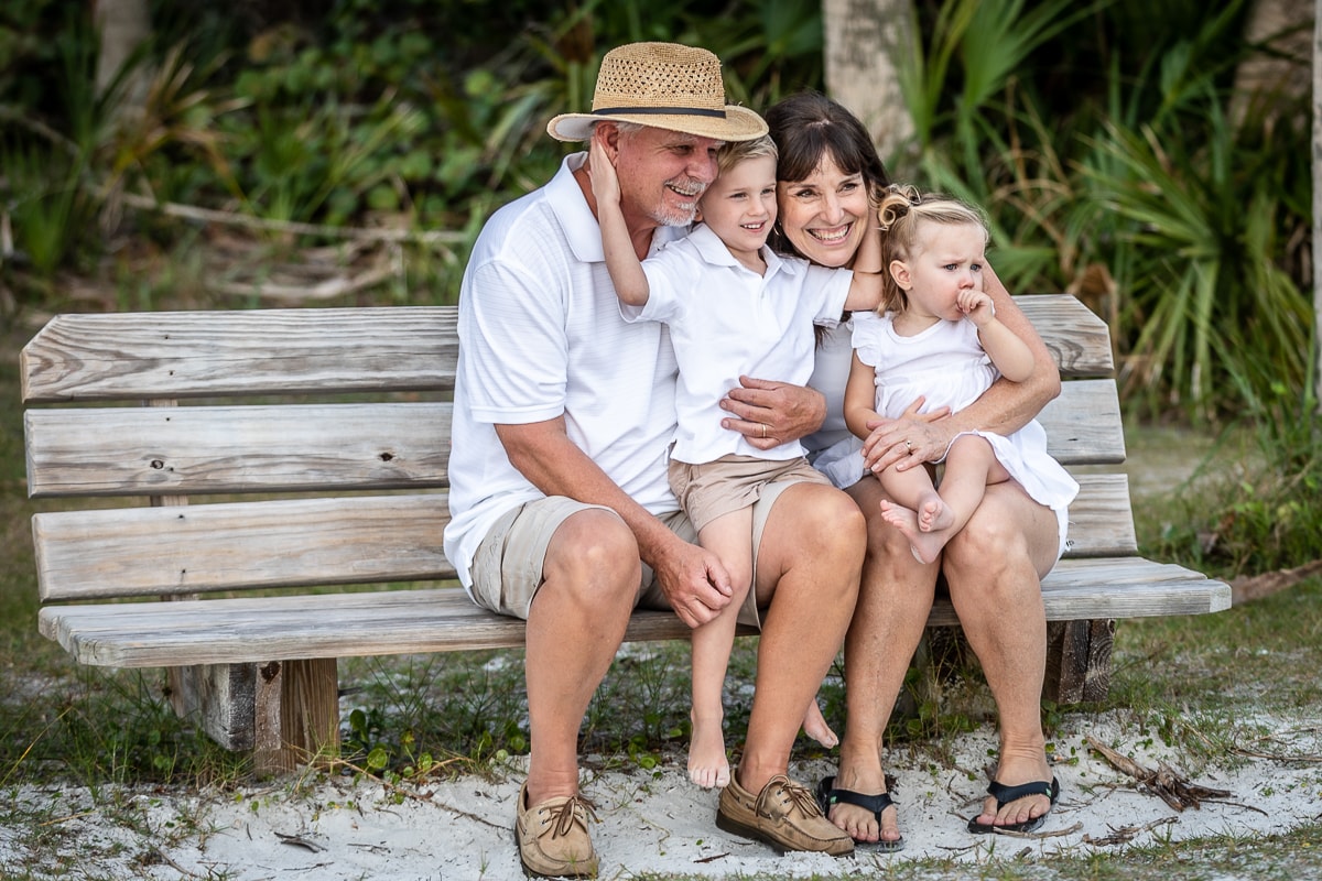 Grandparents with two grandchildren on beach bench