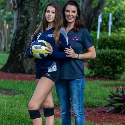 Two women with volleyball outdoors