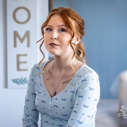 Woman with red hair wearing blue patterned shirt