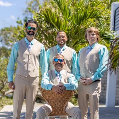 Four men matching outfits tropical setting