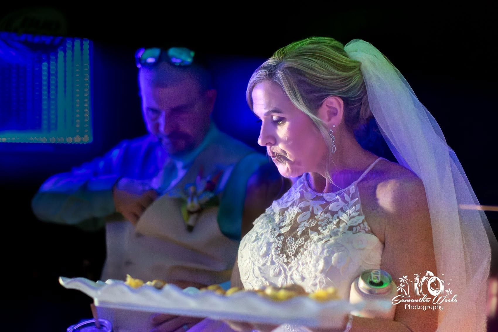 Bride cutting wedding cake neon lighting