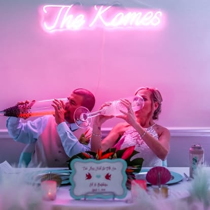 Two women celebrating with champagne neon sign